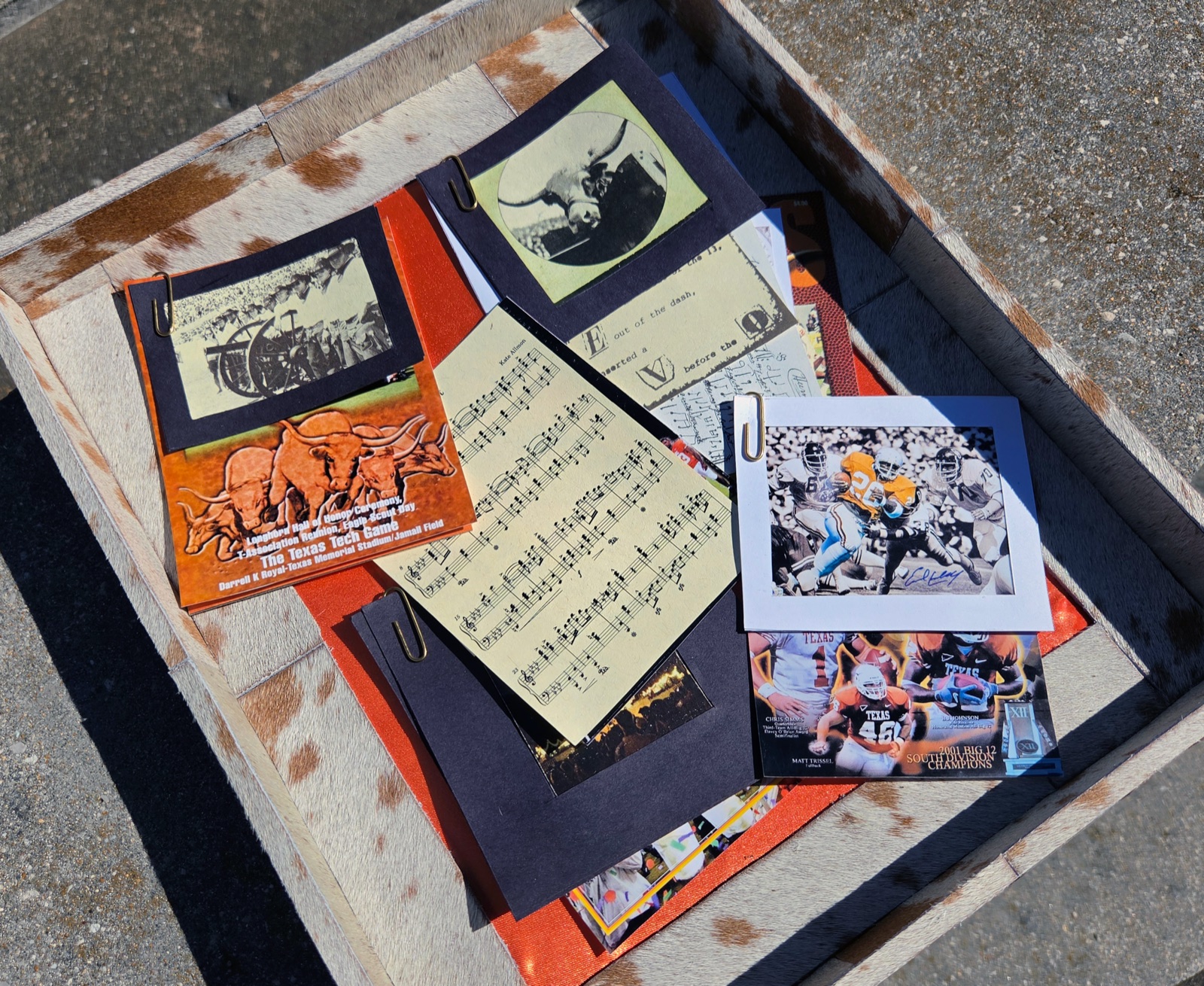 Collected Longhorns ephemera fanned out on the cowhide: sheet music, program covers, tickets and photographs
