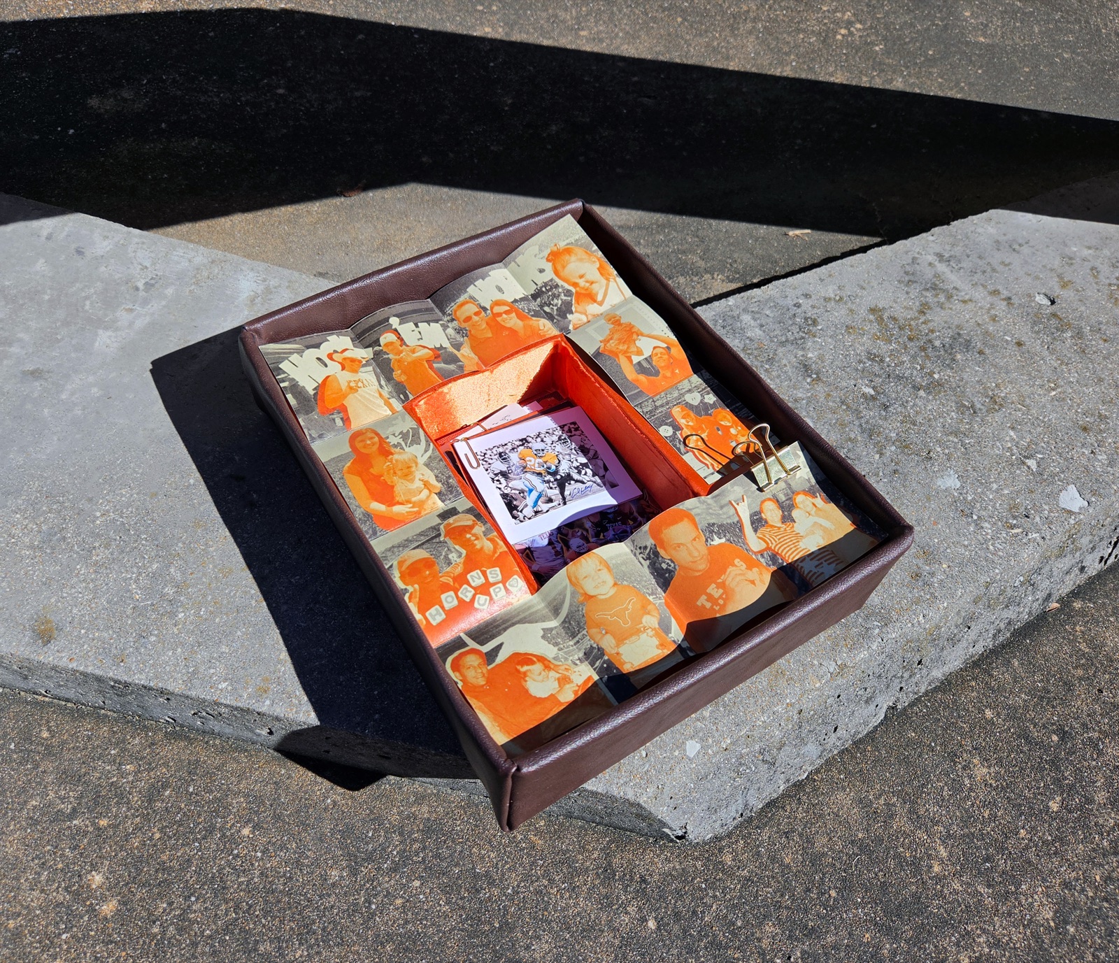 The open box with the book unfolded across the base, revealing the burnt orange satin inner chamber